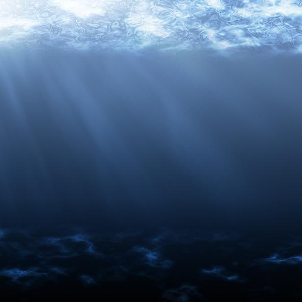 Sonnenstrahlen scheinen durch das Wasser auf den Meeresgrund.