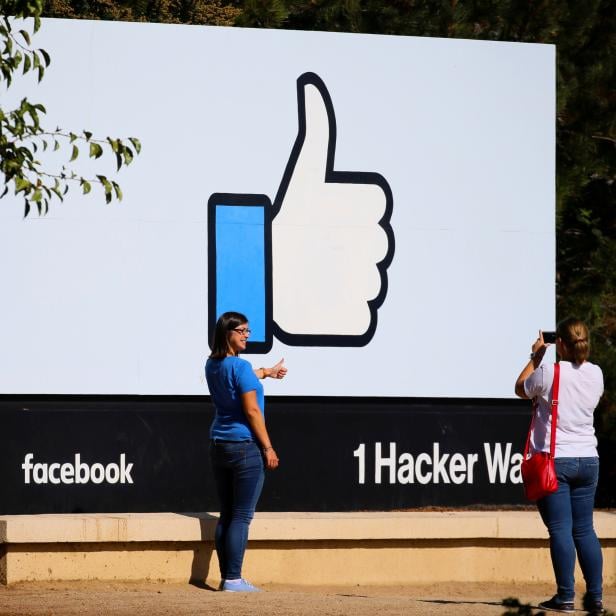 FILE PHOTO: Two women take photos in front of the entrance sign to Facebook headquarters in Menlo Park