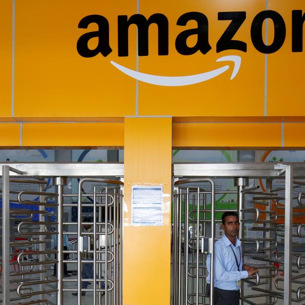 FILE PHOTO: An employee of Amazon walks through a turnstile gate inside an Amazon Fulfillment Centre (BLR7) on the outskirts of Bengaluru