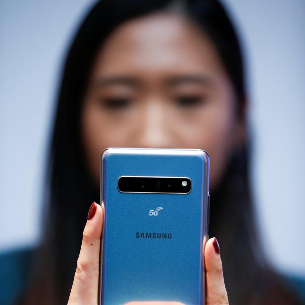 A Samsung employee poses with the new Samsung Galaxy S10 5G smartphone at a press event in London