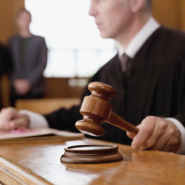 Judge holding gavel in courtroom