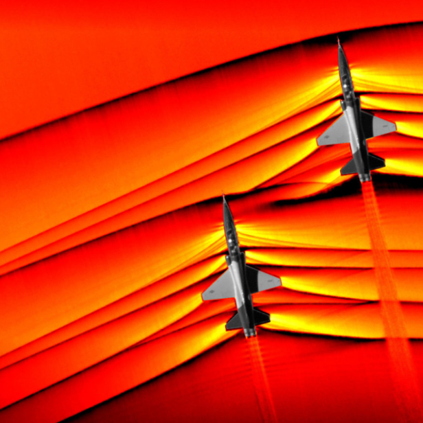 Zwei Kampfflugzeuge fliegen vor einem orangefarbenen Hintergrund.