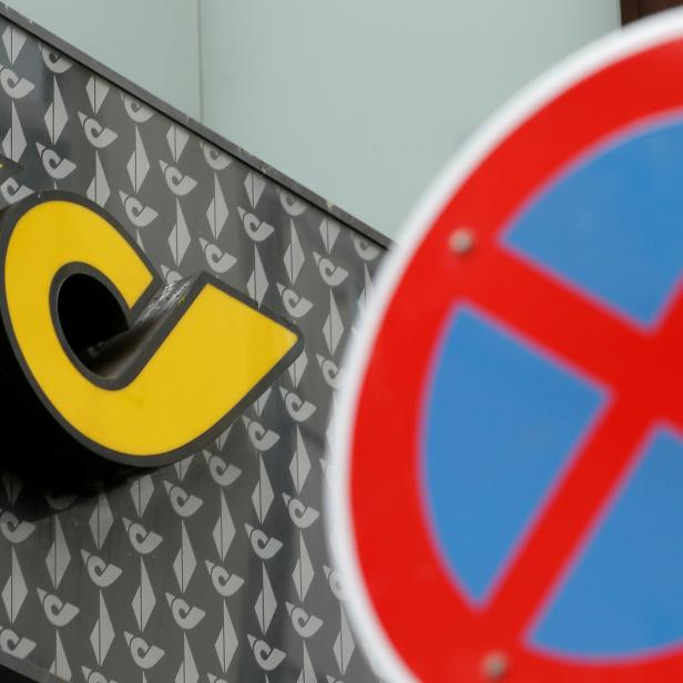 FILE PHOTO: The logo of Austrian Post is seen behind a traffic sign at a branch office in Vienna