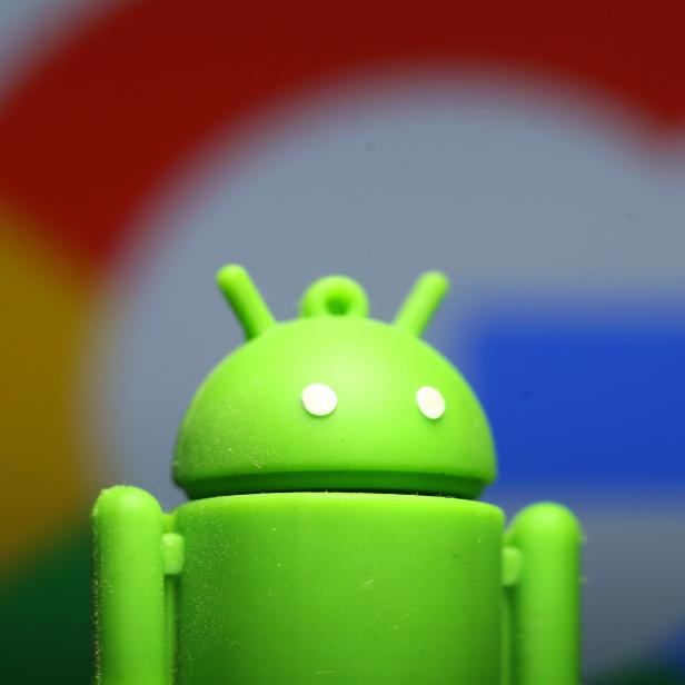 A 3D printed Android mascot Bugdroid is seen in front of a Google logo in this illustration