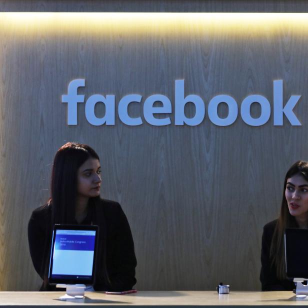 Women wait at Facebook's kiosk at the India Mobile Congress 2018 in New Delhi