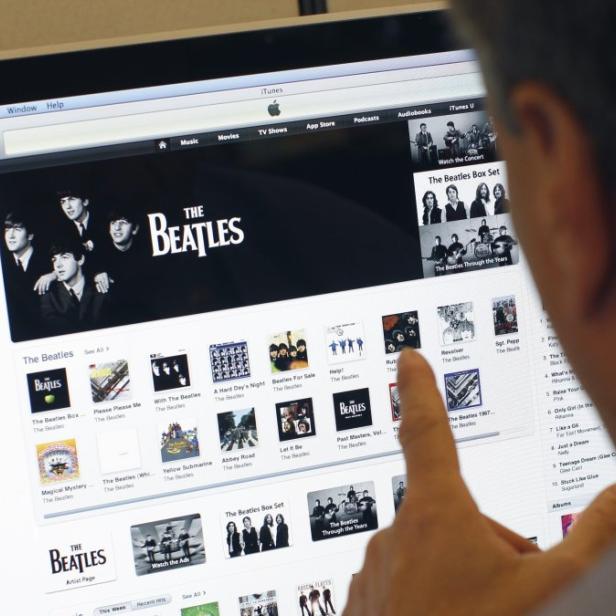 A man poses as he looks at music from the legendary band The Beatles on Apple&#039;s itunes music store website seen on an imac computer in New York, November 16, 2010. Apple inc. announced Tuesday that The Beatles&#039; 13 albums would be available for downloading through the itunes music store, the world&#039;s number one digital music retailer. REUTERS/Mike Segar (UNITED STATES - Tags: ENTERTAINMENT BUSINESS)