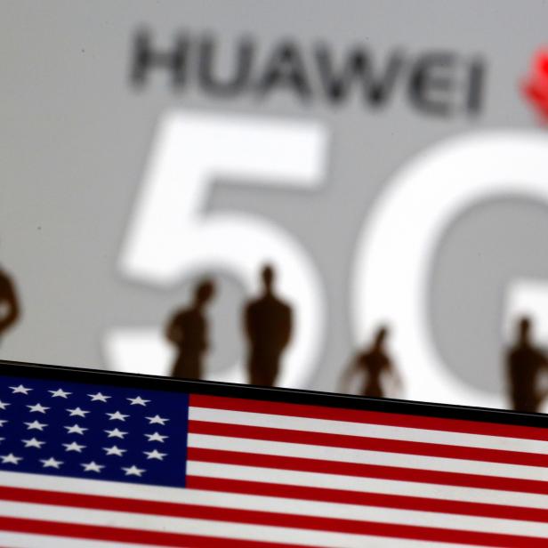 Small toy figures are seen in front of a displayed Huawei and 5G network logo in this illustration picture