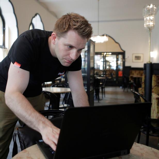 Austrian lawyer and privacy activist Schrems prepares his laptop during a Reuters interview in Vienna