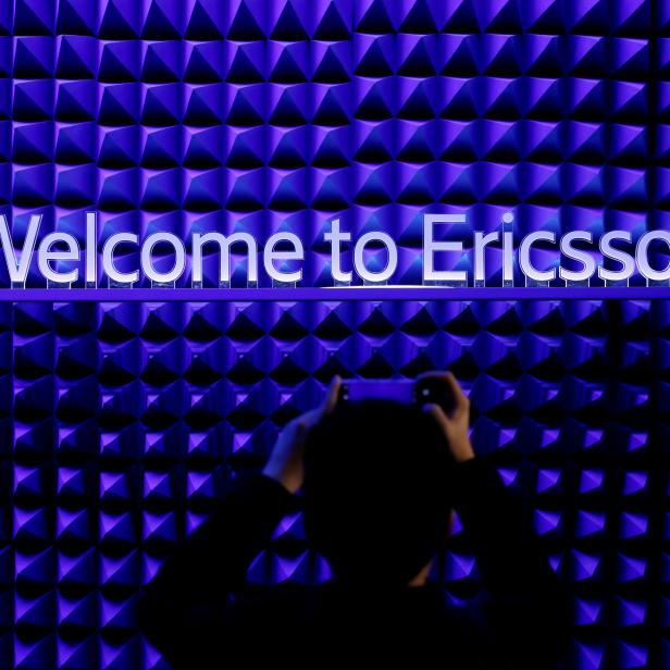 FILE PHOTO: A visitor takes a picture with his mobile phone in front of the Ericsson booth at the Mobile World Congress in Barcelona