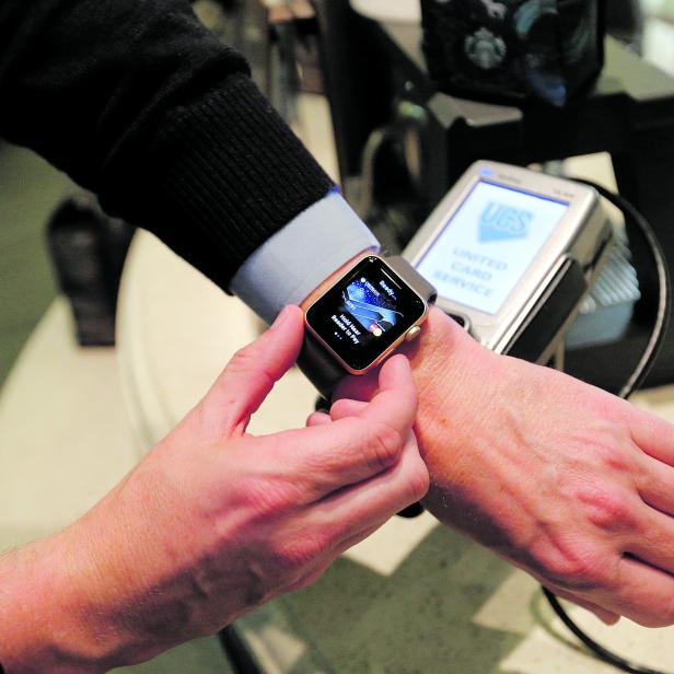 FILE PHOTO: A man uses an Apple Watch to demonstrate the mobile payment service Apple Pay at a cafe in Moscow, Russia