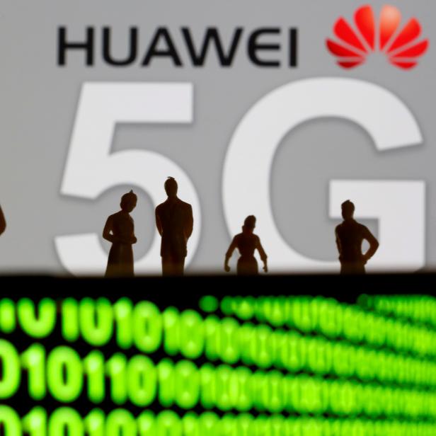 FILE PHOTO: Small toy figures are seen in front of a displayed Huawei and 5G network logo in this illustration picture