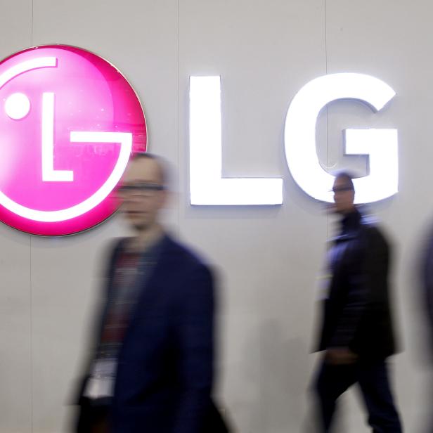 FILE PHOTO: People walk past an LG Electronics logo during the Mobile World Congress in Barcelona