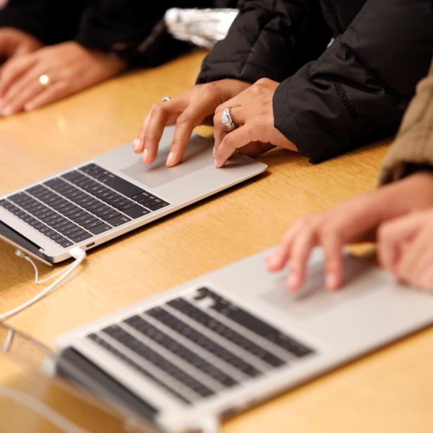 People look at  MacBook Airs at the World Trade Center Apple Store during a Black Friday sales event in Manhattan, New York City