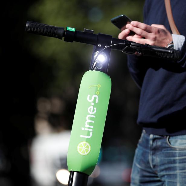 Limes France director Arthur-Louis Jacquier poses near a dock-free electric scooter Lime-S by California-based bicycle sharing service Lime on their launch day in Paris