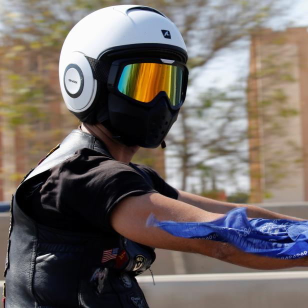 A member of Egyptian motorcycle club "Road Hammers" looks on while riding down a highway in Cairo