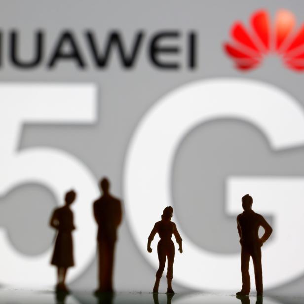 FILE PHOTO: Small toy figures are seen in front of a displayed Huawei and 5G network logo in this illustration picture