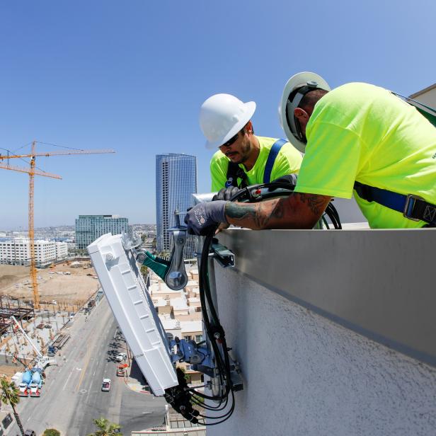 FILE PHOTO: Telecommunication workers Chris Viens and Guy Glover install a new 5G antenna system for AT&T's 5G wireless network in downtown San Diego