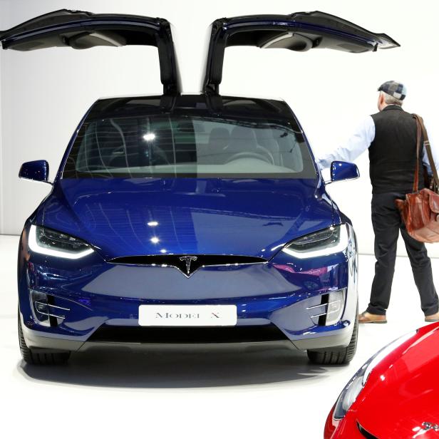 A visitor inspects a Tesla Model X electric vehicle at Brussels Motor Show