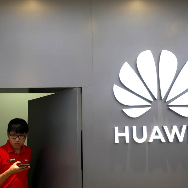 A staff uses a phone as he works at Huawei Flagship Store in Bangkok