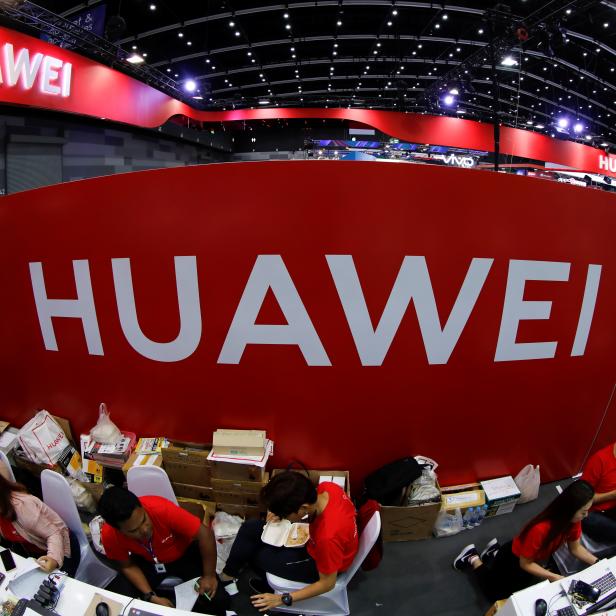 Workers sit at the Huawei stand at the Mobile Expo in Bangkok