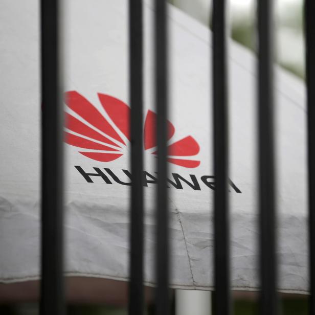 FILE PHOTO: A Huawei logo is seen outside the fence at its headquarters in Shenzhen