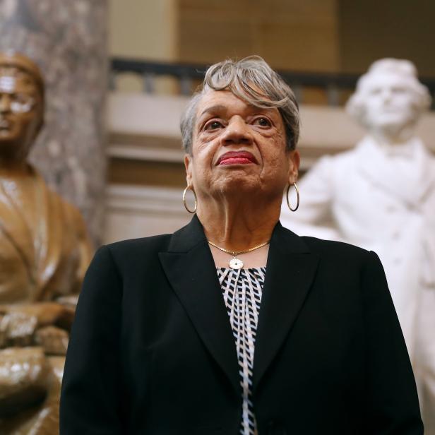 Eine Frau steht vor zwei Statuen in einem Gebäude.
