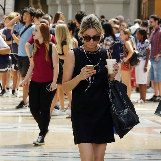 FILE PHOTO: A woman checks on her mobile phone downtown Milan, Italy