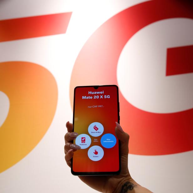 An employee displays a Huawei 5G Smartphone Mate 20X smartphone at a Sunrise telecommunications shop in Opfikon