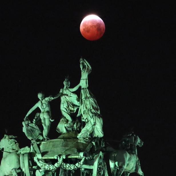 The moon is seen beside a quadriga on the top of the Cinquantenaire arch during a total lunar eclipse known as the "Super Blood Wolf Moon", in Brussels