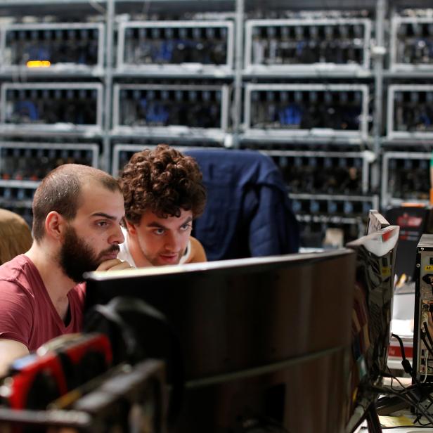 Employees work on bitcoin mining computers at Bitminer Factory in Florence