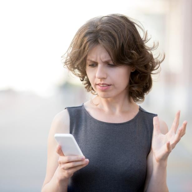 Young business woman irritated with her phone