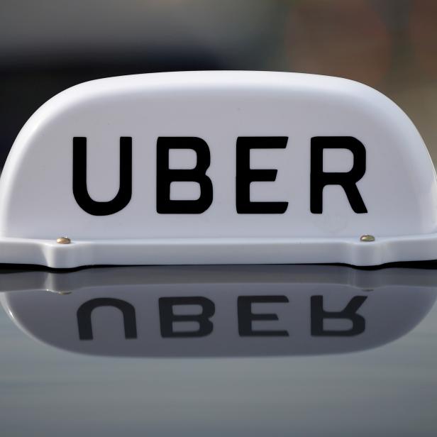 FILE PHOTO: The Logo of taxi company Uber is seen on the roof of a private hire taxi in Liverpool