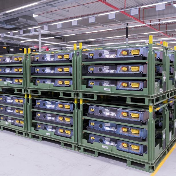 FILE PHOTO: A employee walks along a battery storage in battery factory at Daimler subsidiary ACCUMOTIVE in Kamenz