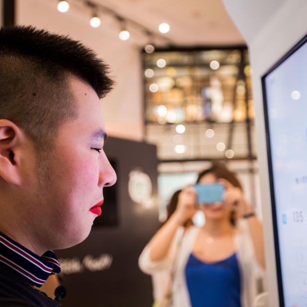 A customer tries Alipay's facial recognition payment solution "Smile to Pay" at KFC's new KPRO restaurant in Hangzhou