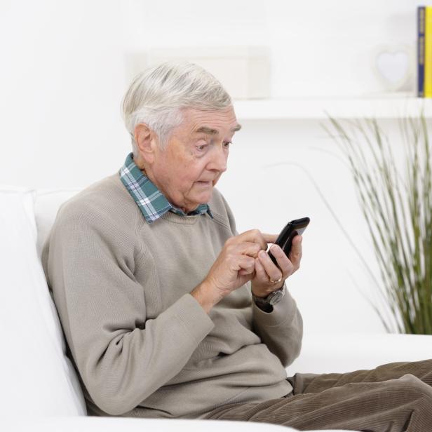 Senior Man Reading A Shocking Message On His Smart Phone