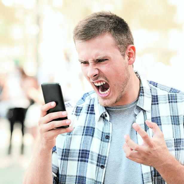 Angry man holding crashed phone