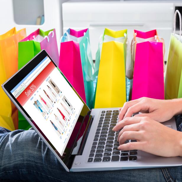 Woman Sitting On Carpet Using Laptop To Shop Online