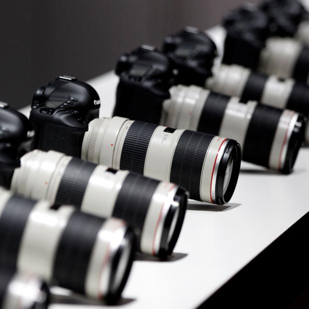 FILE PHOTO: Canon cameras with lenses are pictured at the stand of Japanese camera maker Canon on the press day of the world's largest fair for imaging in Cologne