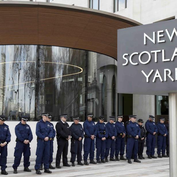 Police officers observe a moment's silence outside New Scotland Yard in Westminster the day after an attack, in London