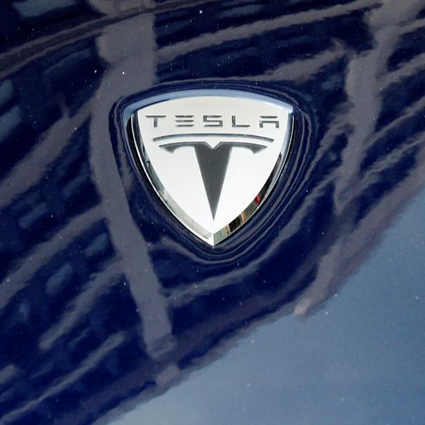 FILE PHOTO: A logo of Tesla Motors on an electric car model is seen outside a showroom in New York