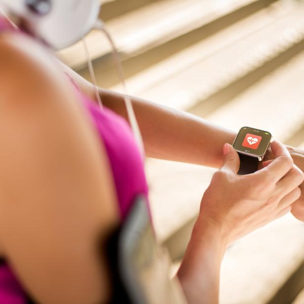 Eine Frau überprüft ihre Herzfrequenz auf einer Smartwatch.
