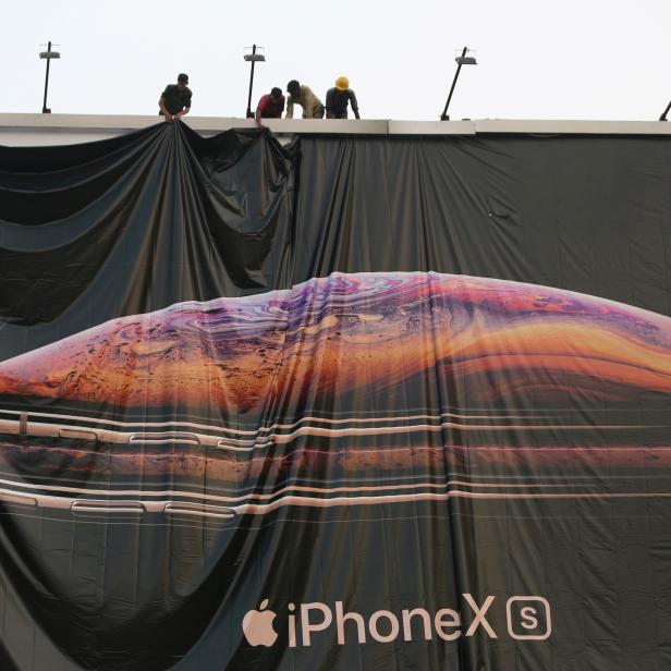 FILE PHOTO: Workers adjust a hoarding of the newly launched iPhone XS in Ahmedabad