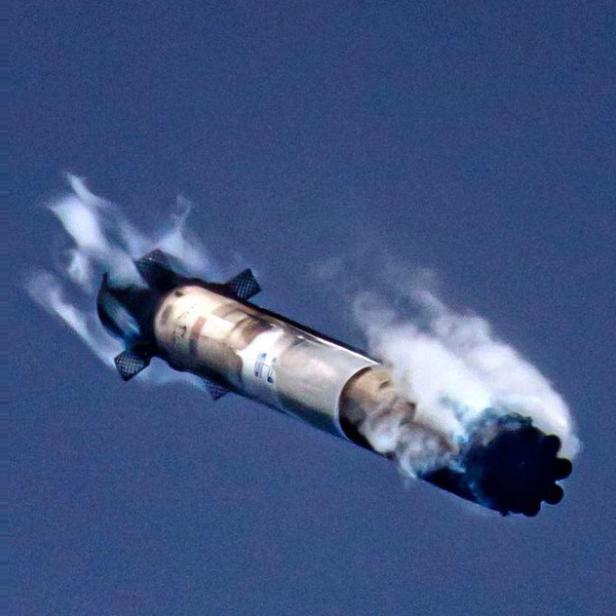 Eine Rakete steigt mit Rauchfahne in den Himmel auf.