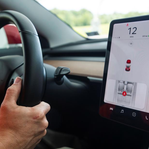 IIHS media relations associate Young demonstrates front crash prevention test on Tesla Model 3 at IIHS-HLDI Vehicle Research Center in Ruckersville, Virginia