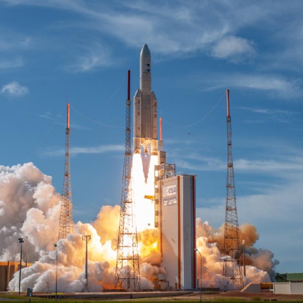 Eine Ariane-Rakete startet mit viel Rauch und Feuer von einer Startrampe.