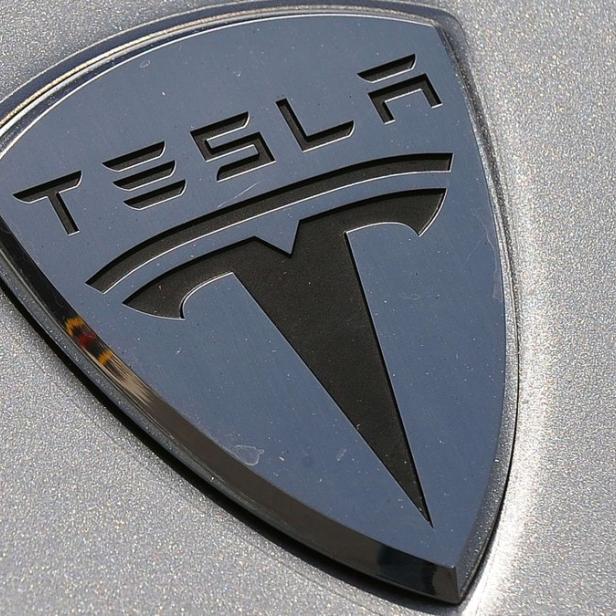 Das Tesla-Logo auf der Motorhaube eines Autos.