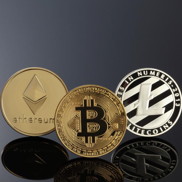 Close up shot of three main cryptocurrencies; bitcoin, ethereum and litecoin in dark surface.