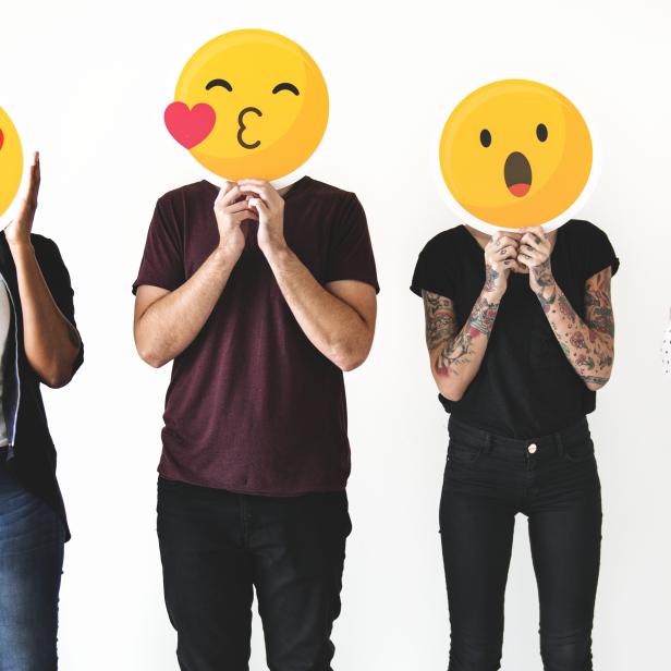 Diverse people holding emoticon