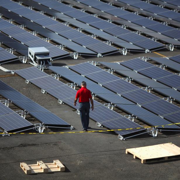 A man walks between solar panels set up by Tesla, at the  San Juan Children's Hospital, after the island was hit by Hurricane Maria in September, in San Juan