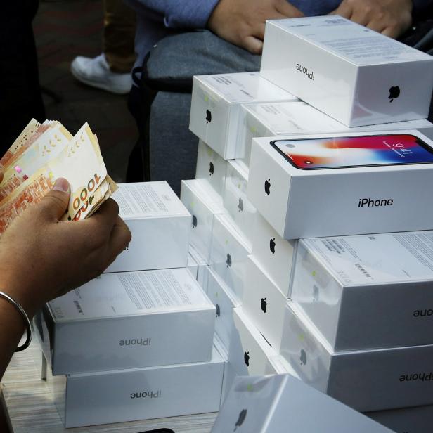 FILE PHOTO: A man pays to buy new iPhone Xs from those who just bought at Apple Stores, on a street in Hong Kong